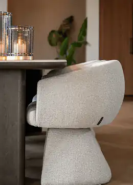 Richmond Interiors kreminės boucle audinio valgomojo kėdė prie tamsaus ąžuolo stalo su stiklinėmis žvakidėmis